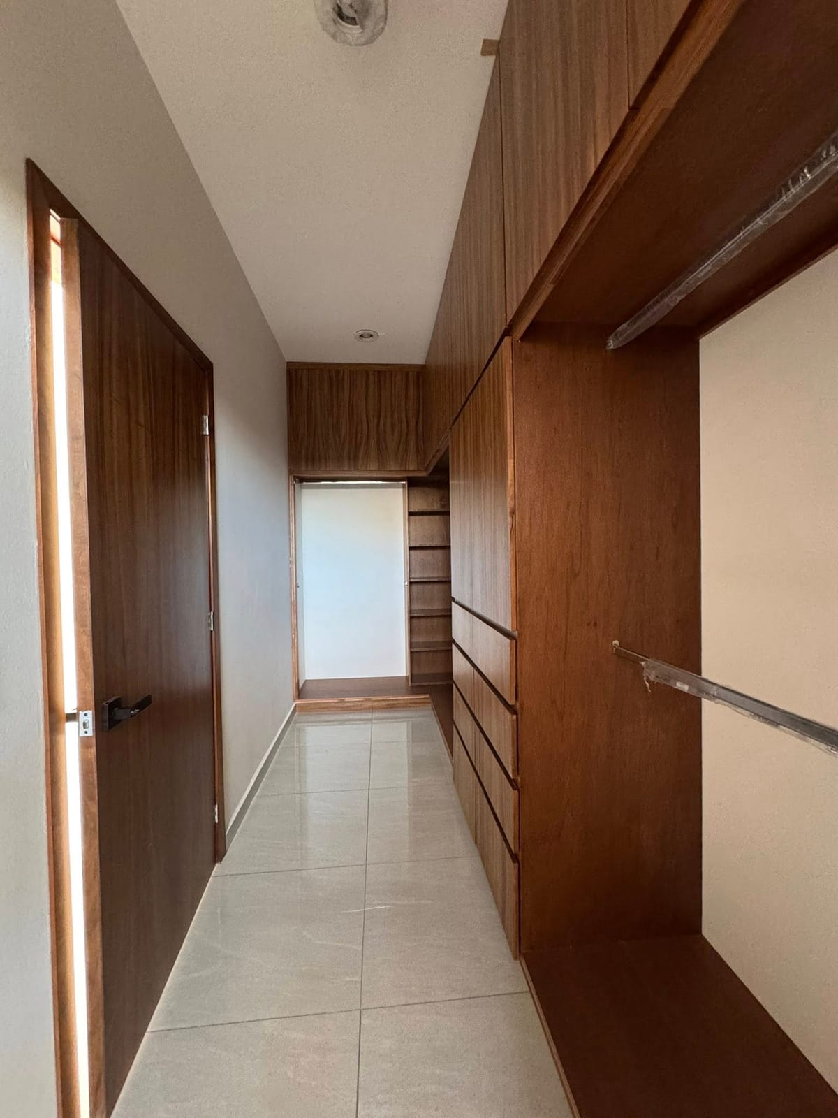 Vestidor con clósets de madera en la recámara principal