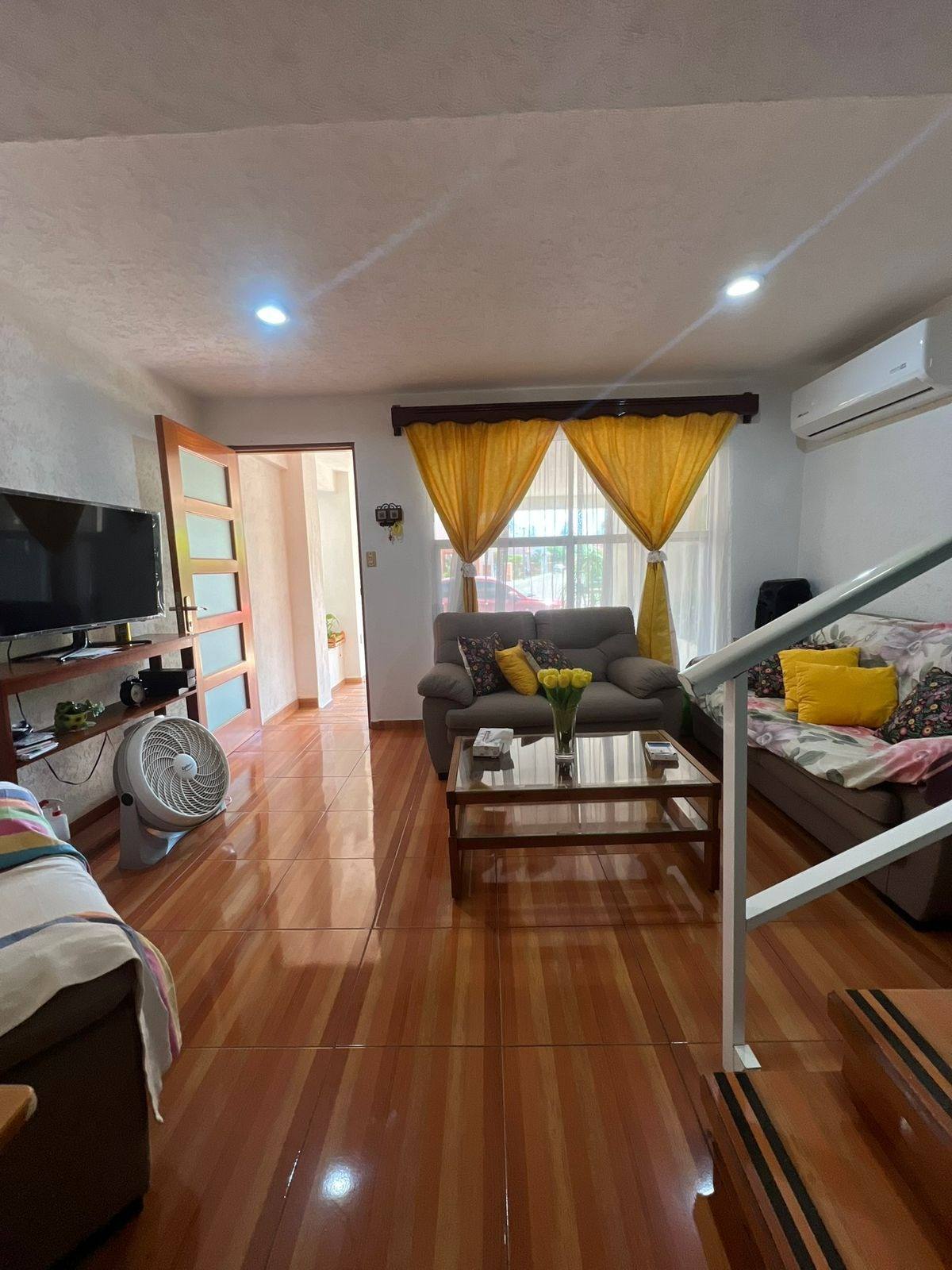 Sala con salida al comedor y escalera en casa de 3 recámaras en Mazatlán
