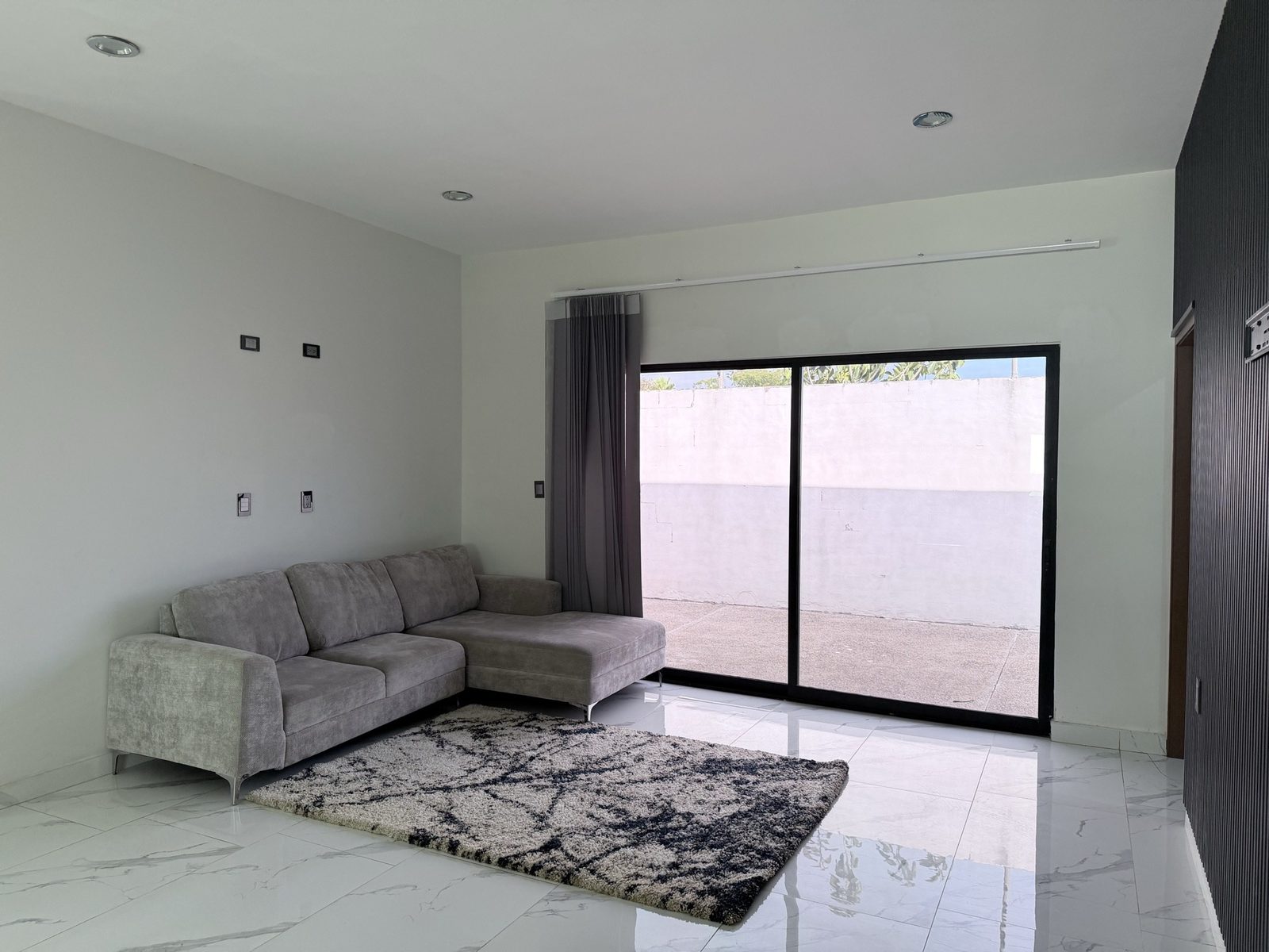 Sala con ventanal corredizo al patio en casa en renta en Soles Parque Residencial, Cerritos