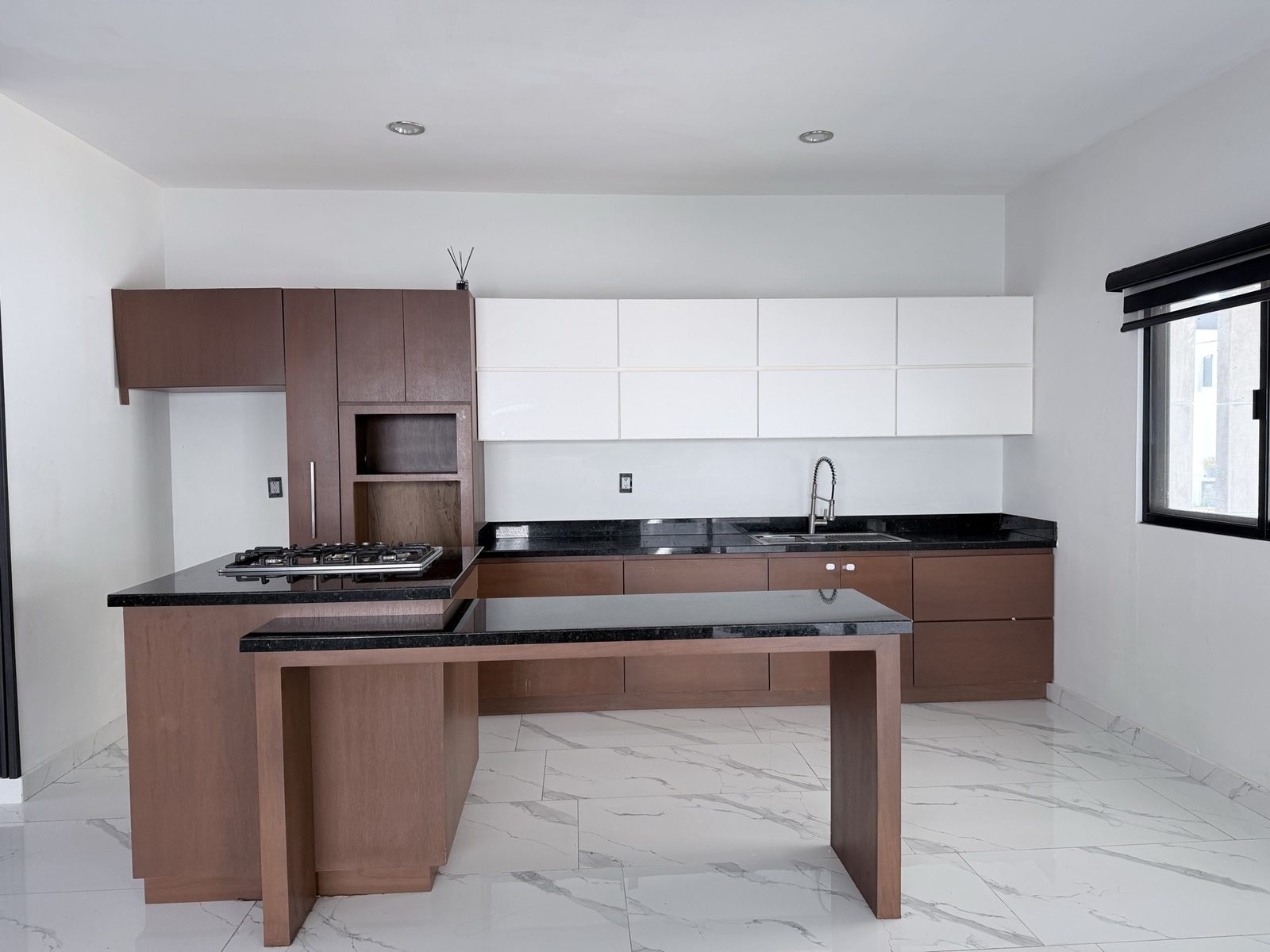 Cocina equipada con isla, parrilla de gas y granito negro en casa en renta en Cerritos, Mazatlán