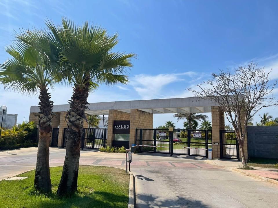 Entrada al coto privado Soles Parque Residencial rodeada de palmeras en Mazatlán