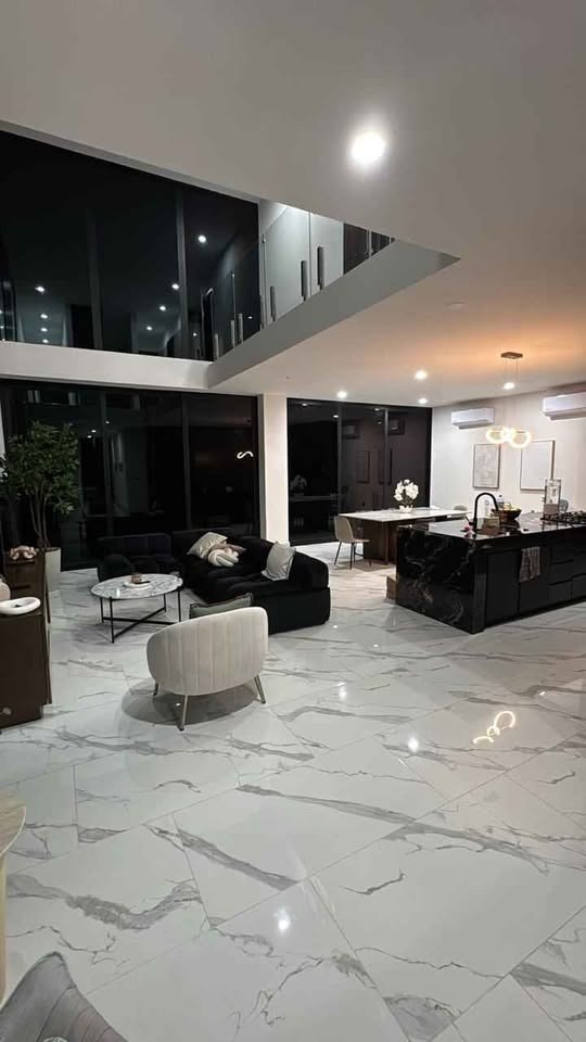 Sala y comedor de doble altura con cocina de mármol negro en casa de 4 recámaras en Mazatlán