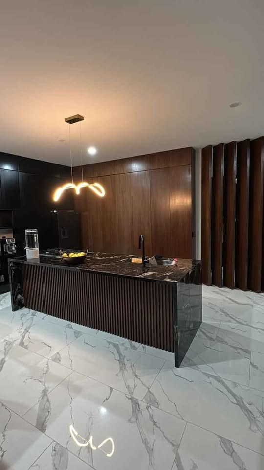 Cocina de madera de nogal con isla y comedor en casa de 4 recámaras en Mazatlán