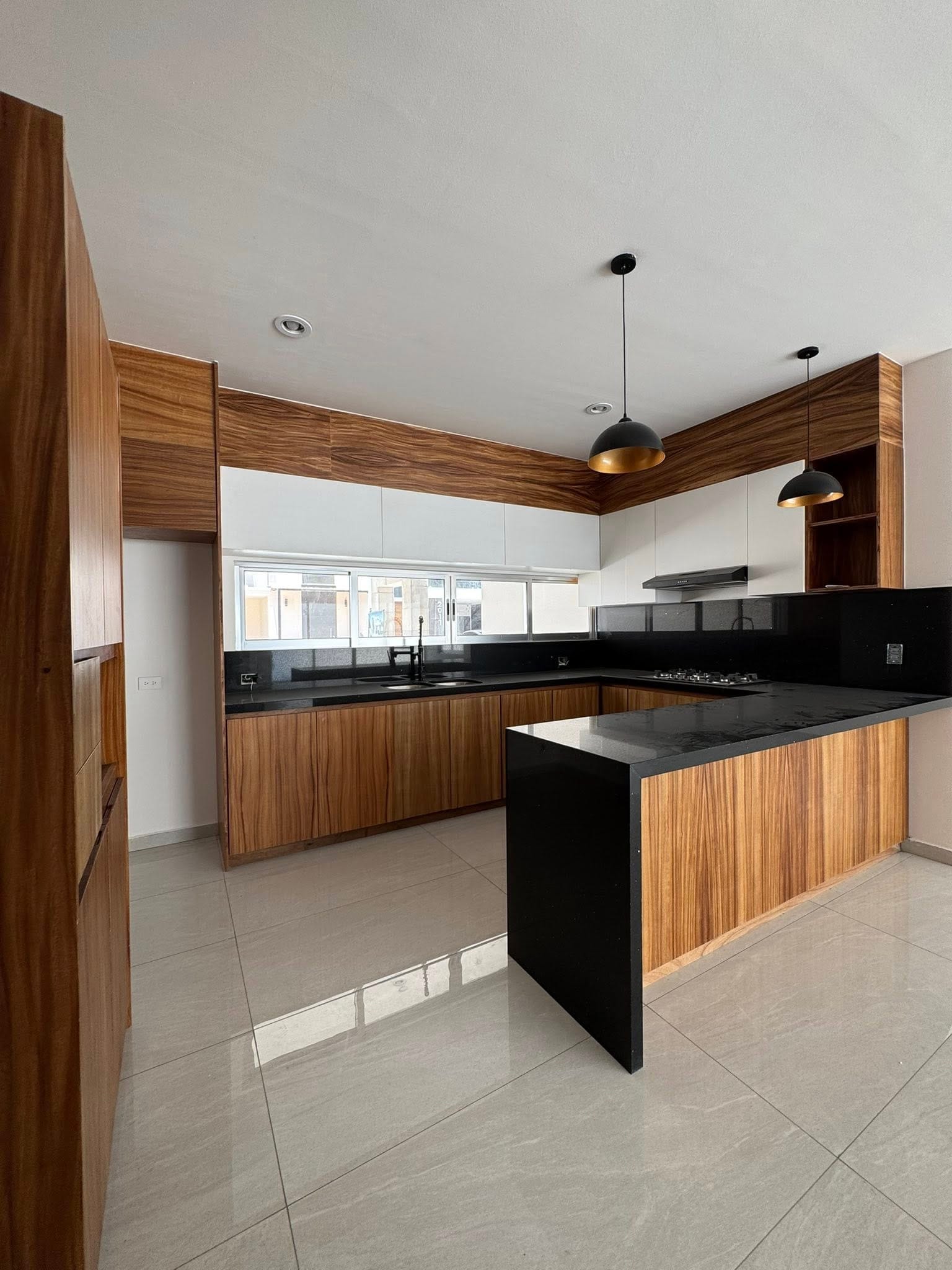 Cocina de parota con barra de granito en casa de Altabrisa Residencial