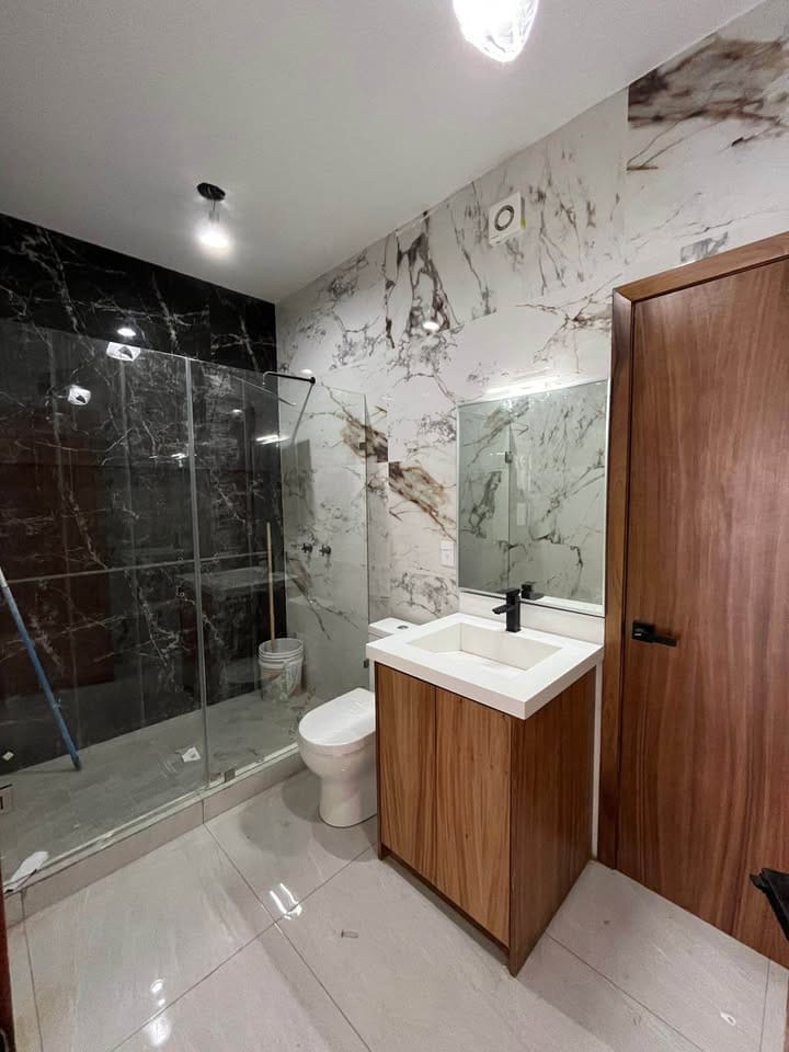 Baño completo con acabados en mármol en casa de Altabrisa