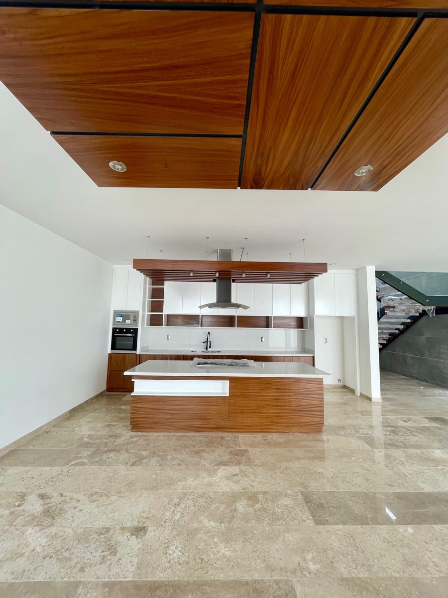 Cocina equipada con isla de granito y alacenas de madera en casa de Paraíso Marina, Mazatlán
