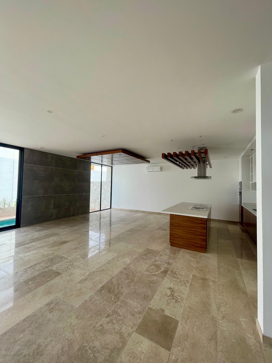 Amplia sala-comedor de planta abierta con isla de cocina y piso de mármol en casa en Mazatlán