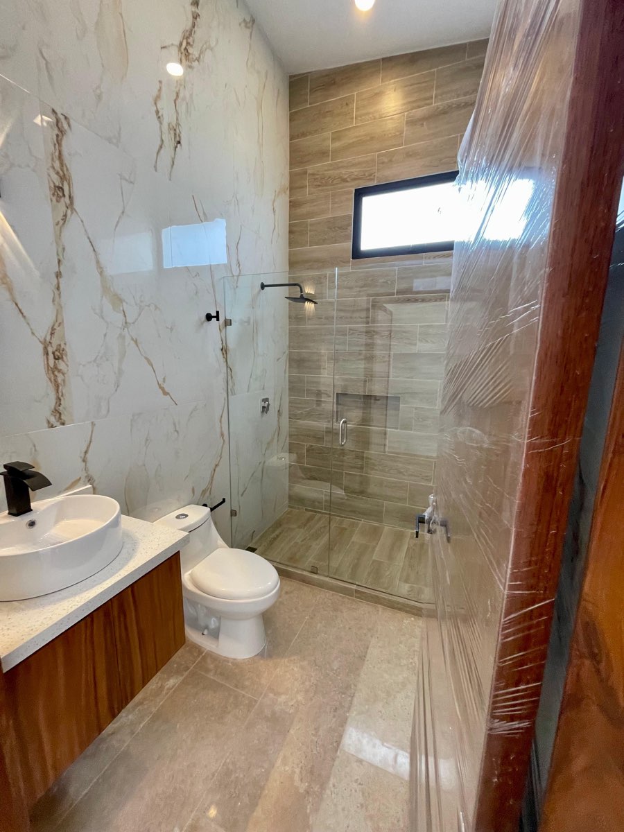 Baño completo con lavabo y regadera de cristal en mármol en casa de Paraíso Marina, Mazatlán