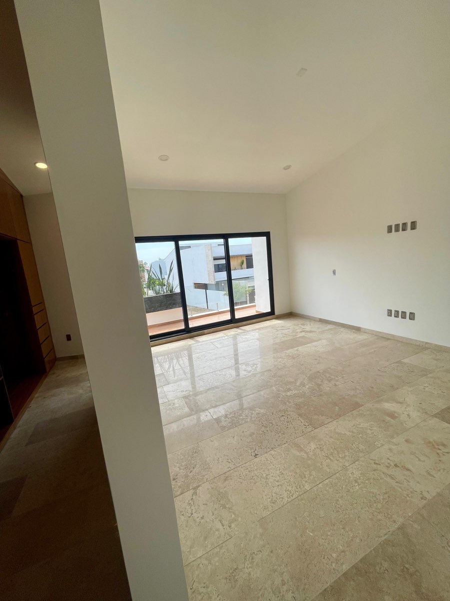 Sala de TV en planta alta con ventanal y acceso a terraza en casa en venta en Mazatlán