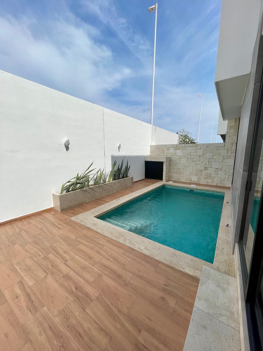 Alberca privada con deck de madera y muro blanco en casa en venta en Mazatlán