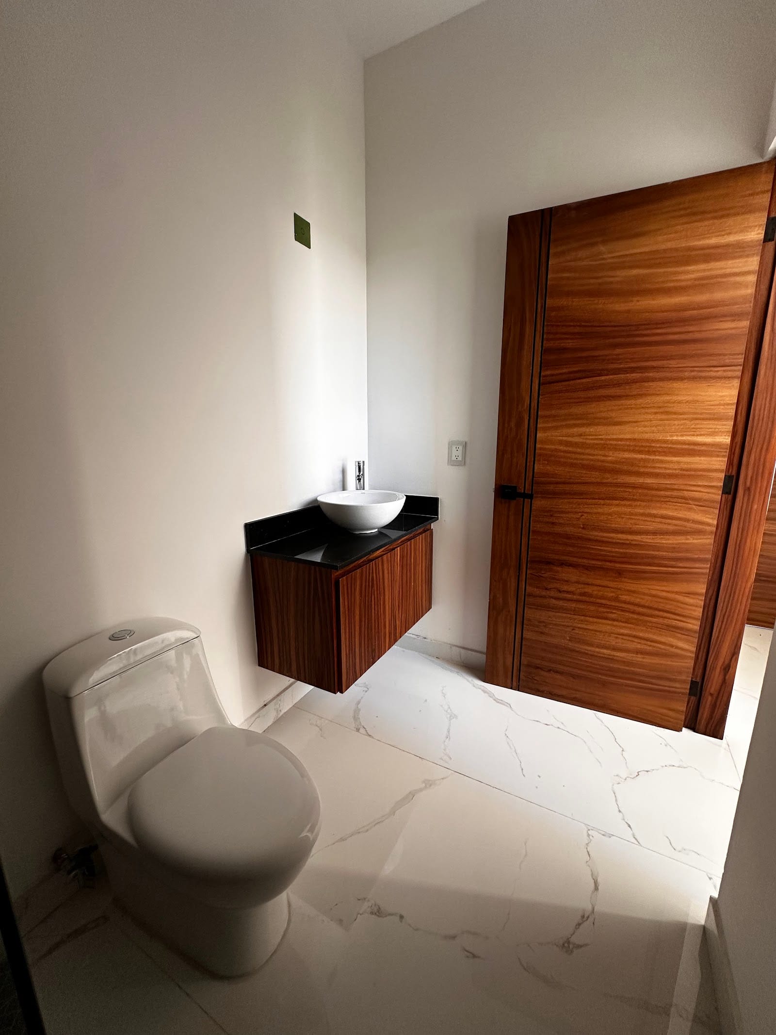 Baño con tocador de madera y acabados en mármol en Neovita Residencial