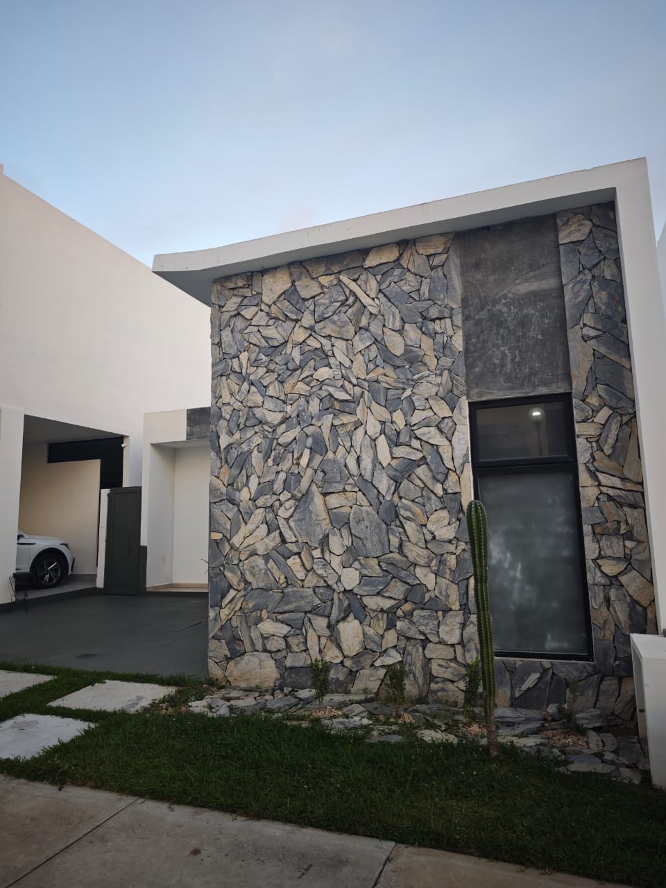 Muro de piedra natural en la fachada de la casa en Soles Parque Residencial, Cerritos