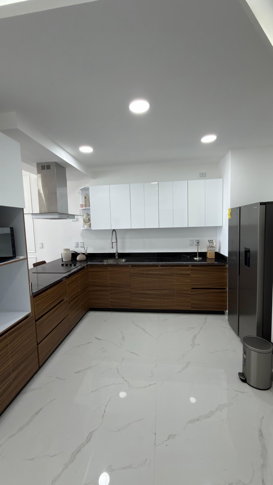 Cocina en L con alacenas de madera y barra de granito en departamento de Playa Brujas, Mazatlán