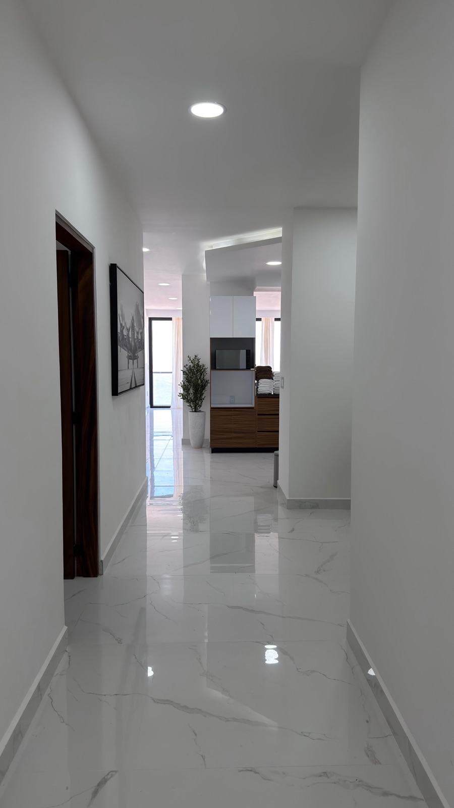 Pasillo de mármol hacia la sala y la cocina en departamento amueblado en Mazatlán