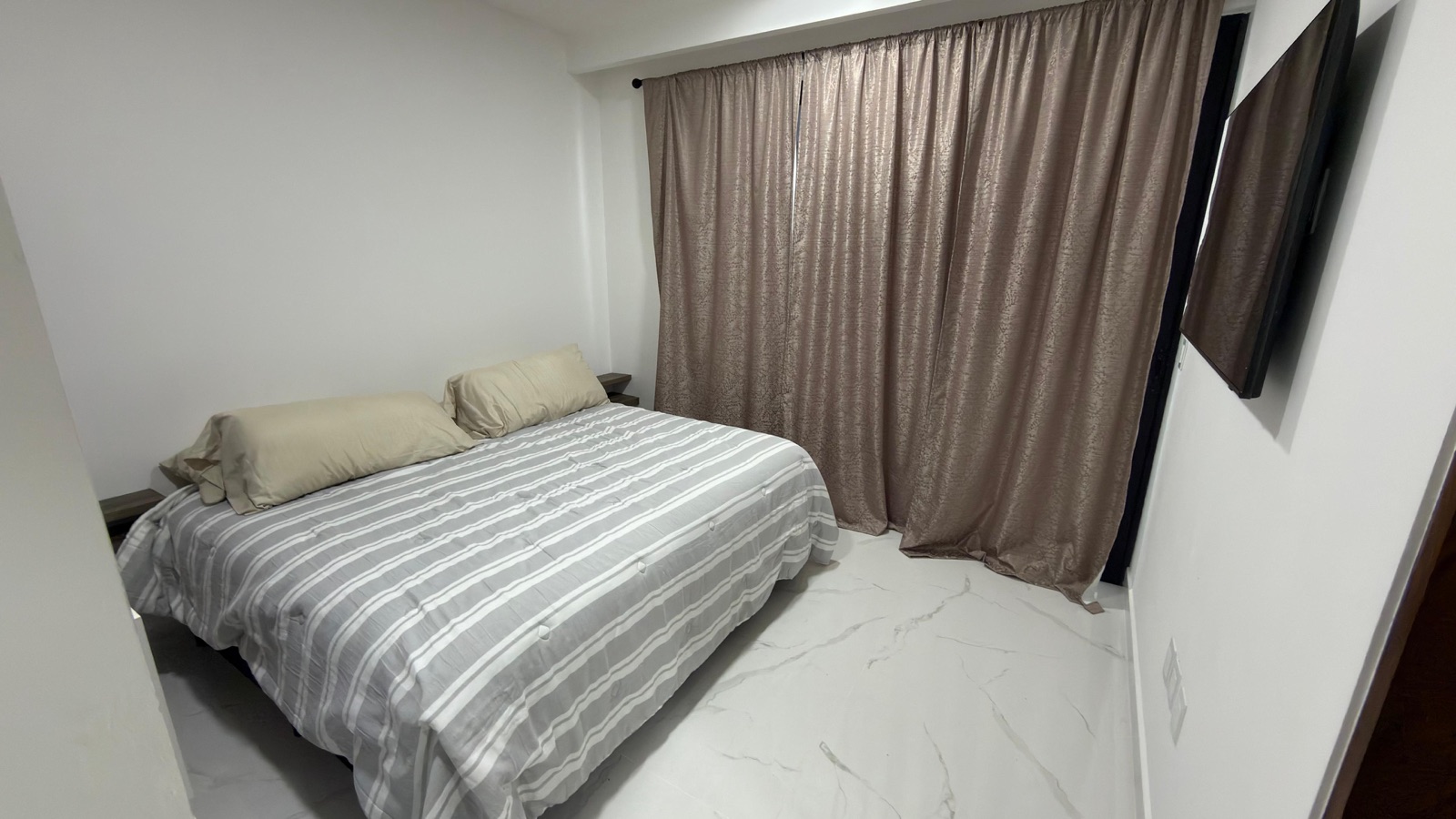 Segunda recámara amueblada con cortinas y piso de mármol en departamento en Mazatlán