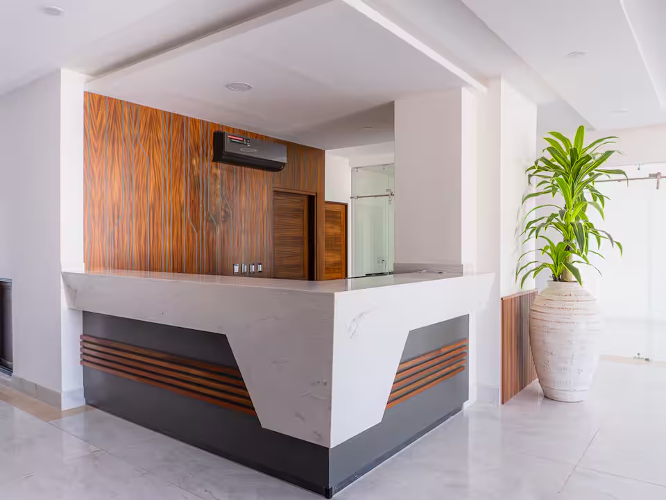 Recepción con counter de mármol y madera en el condominio Grand Sunset, Mazatlán