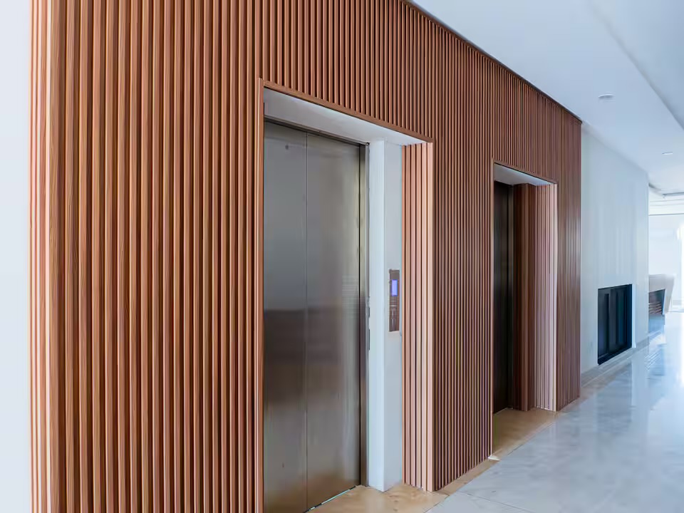 Elevadores con muro de madera en el lobby del condominio Grand Sunset, Mazatlán
