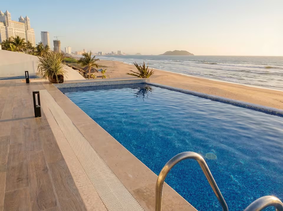Alberca frente al mar al atardecer con vista a Isla de Venados en Mazatlán