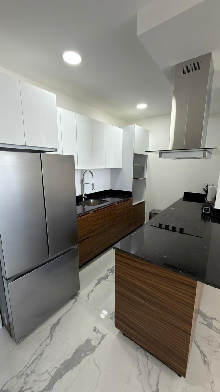 Cocina integral con isla de granito negro y campana de acero en departamento de Playa Brujas, Mazatlán