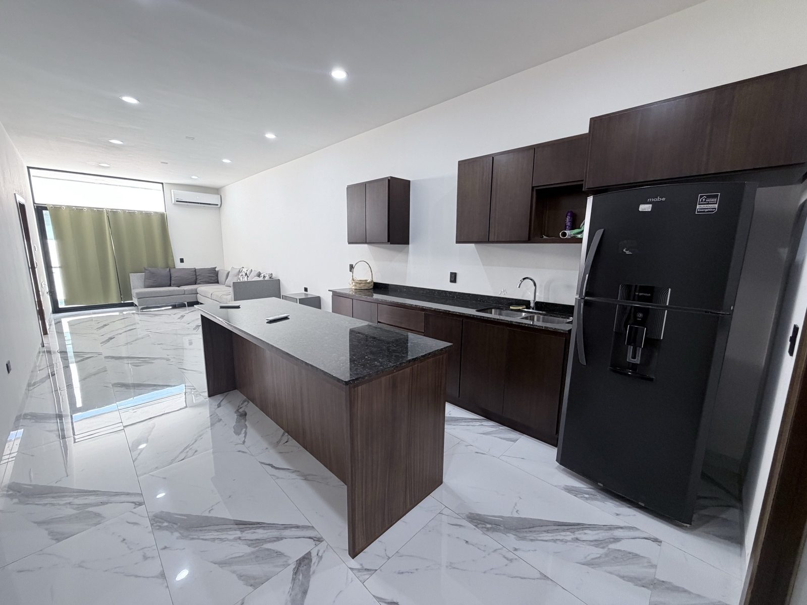 Cocina con isla de granito abierta a la sala en departamento en venta en Sábalo Country, Mazatlán