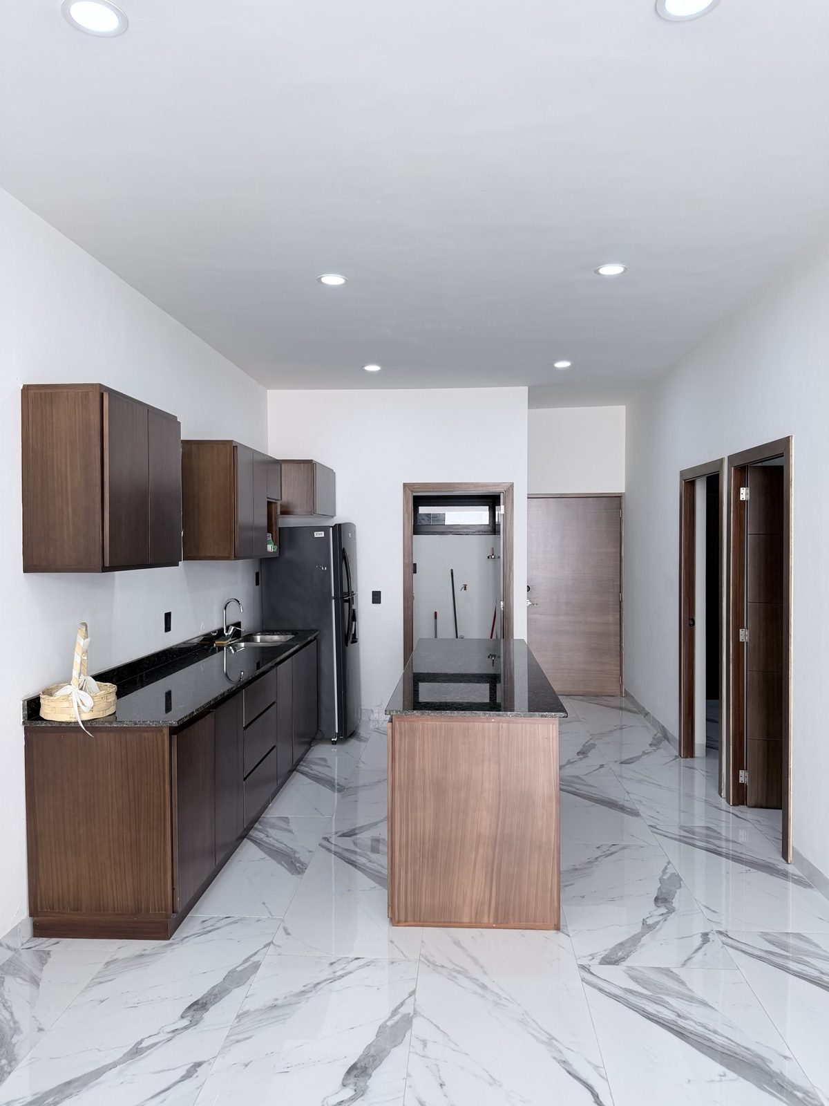Cocina vista desde el acceso, con piso de porcelanato tipo mármol, en departamento en Mazatlán